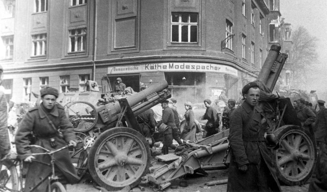 Raudonarmiečiai plėšia Karaliaučių. Antrame plane - vokiečių 150 mm pabūklai sIG 33 (schweres Infanterie Geschütz 33).