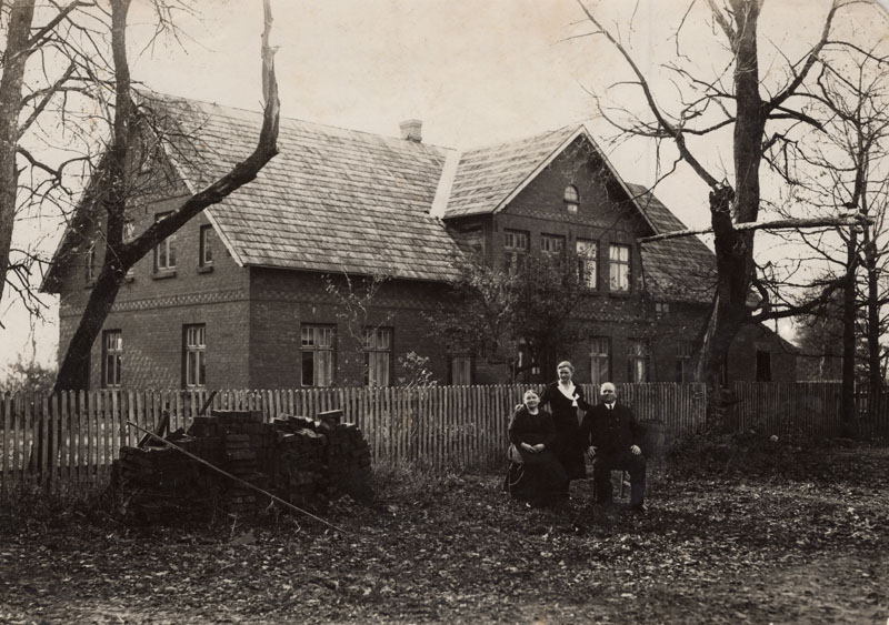 Mėta Pažėraitė su tėvais prie namų Miškogalių kaime, 1932. Kairėje sukrauta plytų krūva, likusi nuo namo statybų 1930 metais.