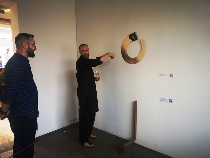 „Užburtas ratas“ - sukurtas iš sulenkto pjūklo - tai uždaras ratas, arba klaidos, kurias mes nuolat kartojame, jeigu iš jų nepasimokome. O apčioje iš sulenkto kirvio sukurtas kūrinys „Perėjimas“ - tai istorija apie transformaciją. „Atrask save, savo prigimtį, pripažink ją ir gyvenk ją priimdamas, ne konfliktuodamas su ja“, - ragino parodos autorius aiškindamas savo kūrinius parodos lankytojams.