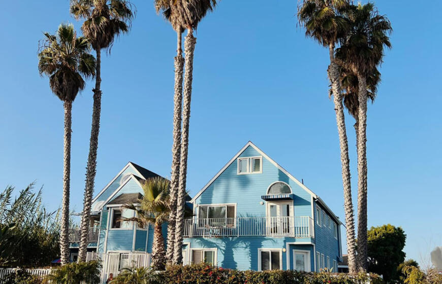 Aukštos palmės ir mieli, spalvoti nameliai – Sano diegas.