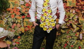 Žinomi žmonės tapo gyvomis gėlėmis puoštų skrybėlaičių parodos „eksponatais“