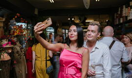 Žinomi žmonės tapo gyvomis gėlėmis puoštų skrybėlaičių parodos „eksponatais“