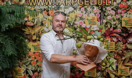 Žinomi žmonės tapo gyvomis gėlėmis puoštų skrybėlaičių parodos „eksponatais“