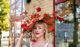 Žinomi žmonės tapo gyvomis gėlėmis puoštų skrybėlaičių parodos „eksponatais“