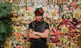 Žinomi žmonės tapo gyvomis gėlėmis puoštų skrybėlaičių parodos „eksponatais“