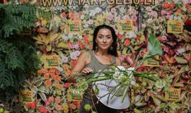 Žinomi žmonės tapo gyvomis gėlėmis puoštų skrybėlaičių parodos „eksponatais“