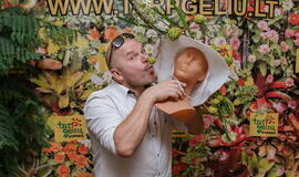 Žinomi žmonės tapo gyvomis gėlėmis puoštų skrybėlaičių parodos „eksponatais“