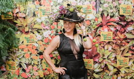 Žinomi žmonės tapo gyvomis gėlėmis puoštų skrybėlaičių parodos „eksponatais“