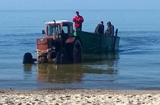 Apsipylęs tepalais traktorius važiuoja į jūrą
