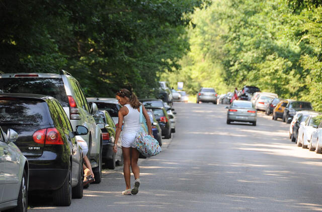 PRISIPRAŠĖ. Vasarą automobiliais nusėtos kelio į Karklę pakelės bei perpildytos stovėjimo aikštelės prie Olando Kepurės neliko nepastebėtos. Jau nuo pirmadienio vairuotojams už tai teks mokėti daugiau. Redakcijos archyvo nuotr.